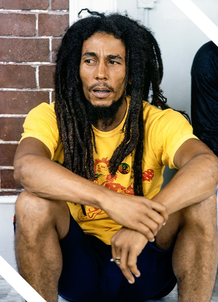 Bob Marley, assis sur un escalier en extérieur